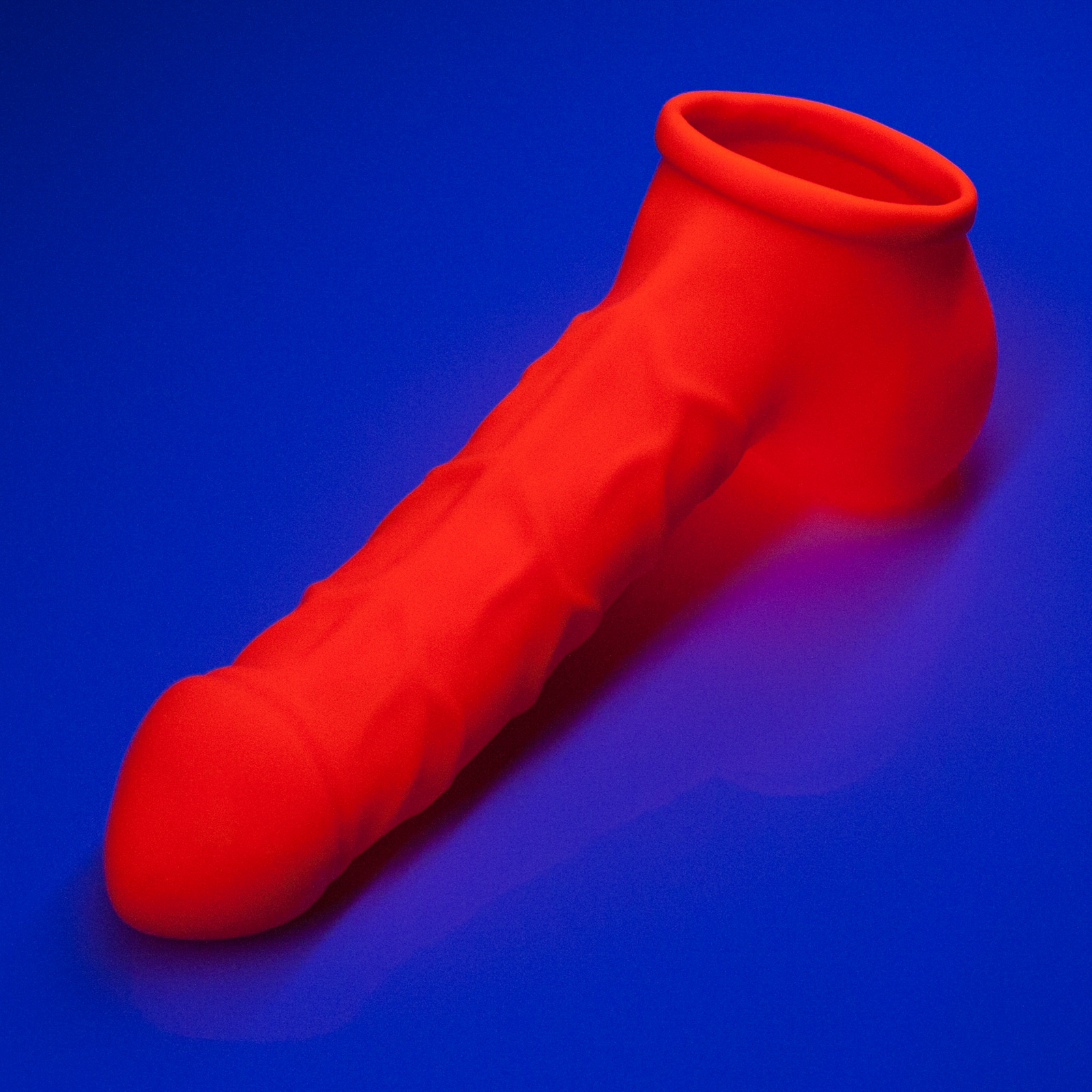 Toylie Latex Penis Sleeve «FRANZ» neon orange (glow effect), with strong veins and molded scrotum