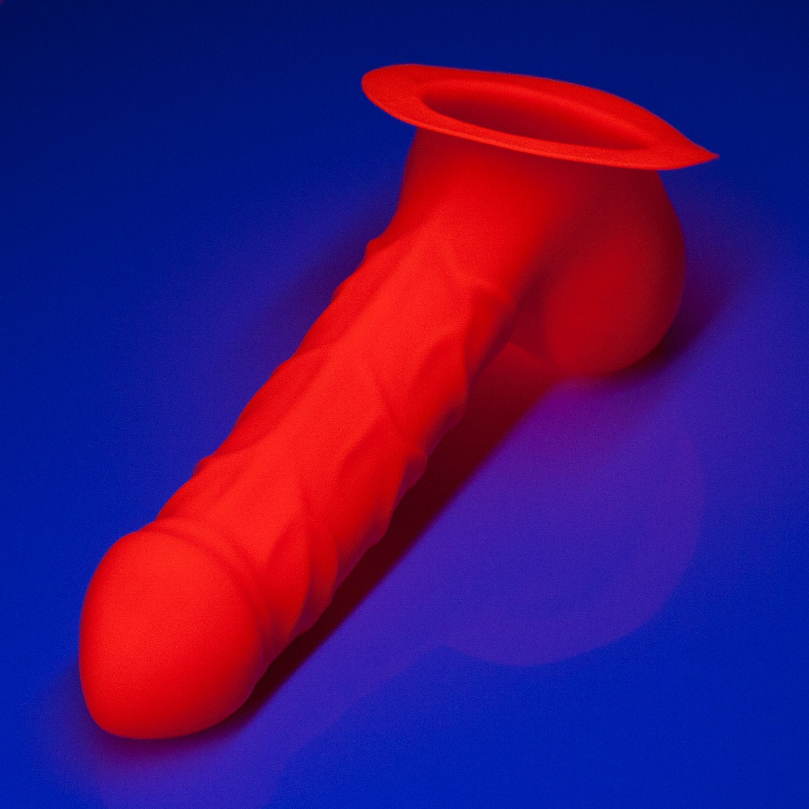 Toylie Latex Penis Sleeve «FRANZ» neon orange (glow effect), with base plate for sticking to latex clothing